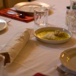 Table setting with bread in parchment for dipping into aforementioned oil